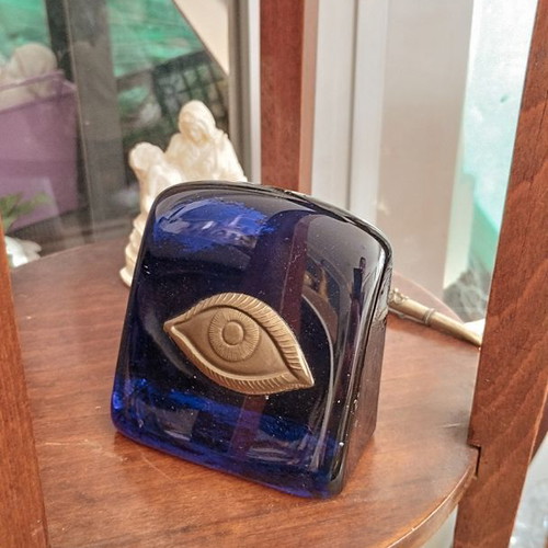 Decorative glass paperweight with metal eye like new