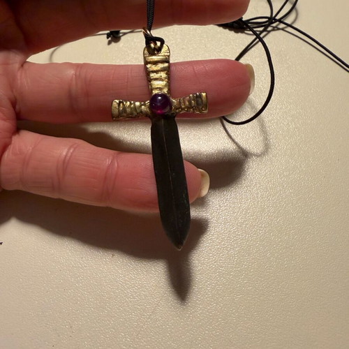 Sword-shaped pendant like new with red stone and leather cord
