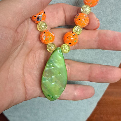 Long necklace with shell pendant, orange and green beads