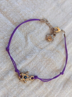 Bracelet with purple cord and metal star and eye