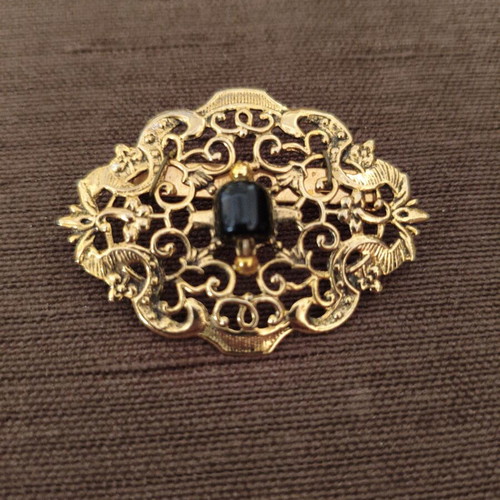 Vintage brooch with intricate filigree design and black stone like new