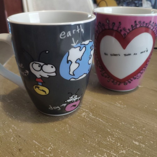 Two collectible mugs like new, featuring Moby and Charlize Theron design