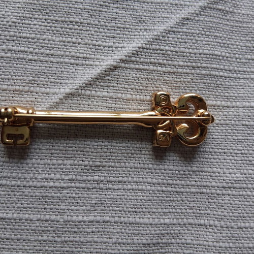 Metal key-shaped pin like new, multicolored, gold tone