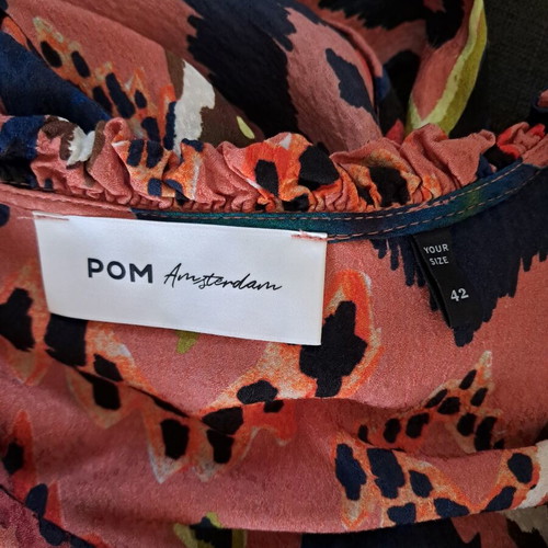 Pom dress used with geometric pattern in pink, blue and green