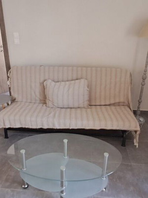 IKEA sofa bed, modern floor lamp, glass coffee table