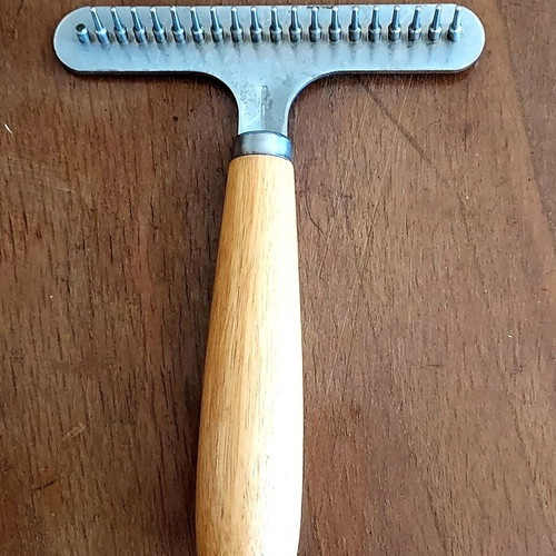 Grooming rake like new with metal teeth and wooden handle