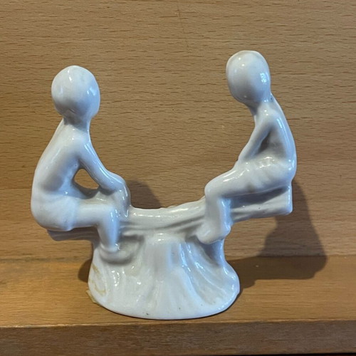 Porcelain children on seesaw gilded like new