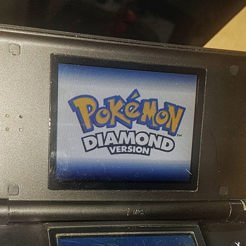 Nintendo DS Lite used with Dialga and Palkia reshell, charger, stylus, and carrying case