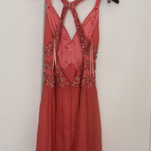 Coral short evening dress with crisscross straps, V neckline, and shiny embroidered beads