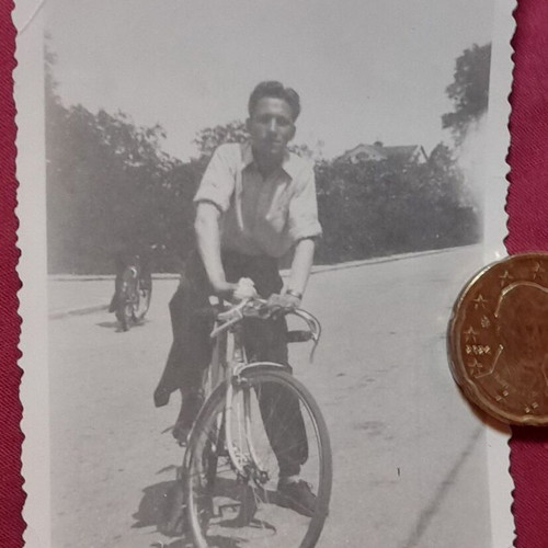 Vintage black and white photo of man with bicycle used, serrated edges