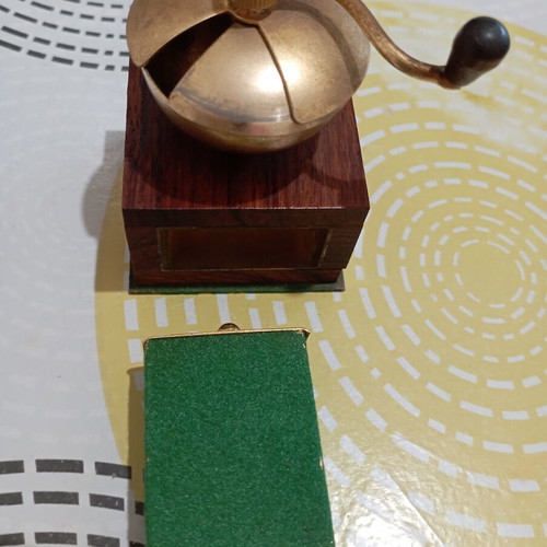 Vintage miniature manual coffee grinder with wooden body and brass hopper