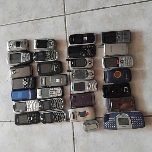 Old mobile phones with chargers and headphones