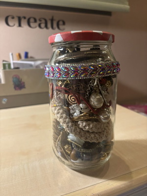 Jar treasure with assorted women's jewelry and accessories