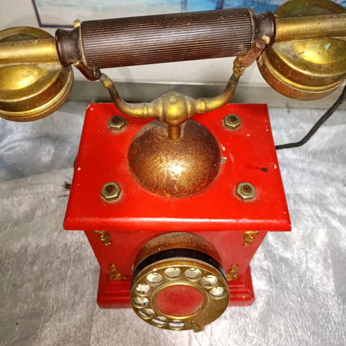 Vintage metal rotary phone, red with gold details
