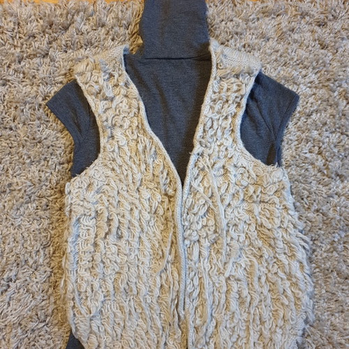 Grey turtleneck top, beige sleeveless fur vest and black stone earrings set