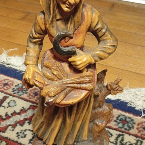 Vintage folk art decorative figurine of elderly peasant harvesting