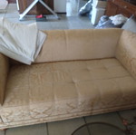 Two beige used two-seater sofas, worn for repair
