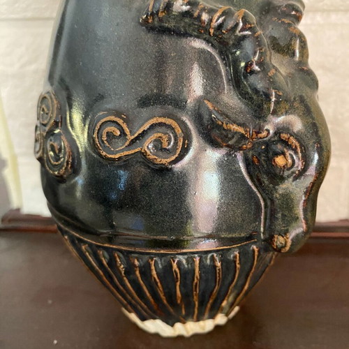 Black ceramic vase with ram’s head decoration