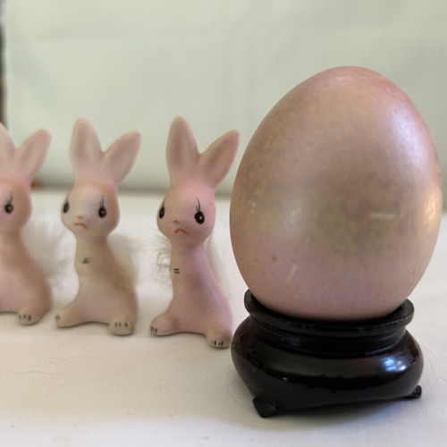 Vintage ceramic pink bunny family figurines with decorative Easter egg