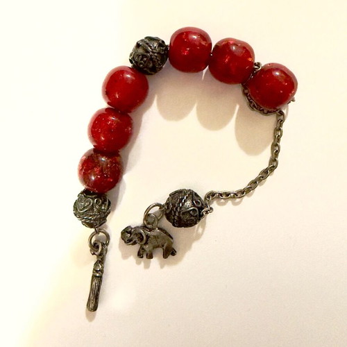 Worry beads with red beads and metal charms used, elephant