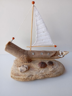 Handmade decorative boat from driftwood on natural schist base