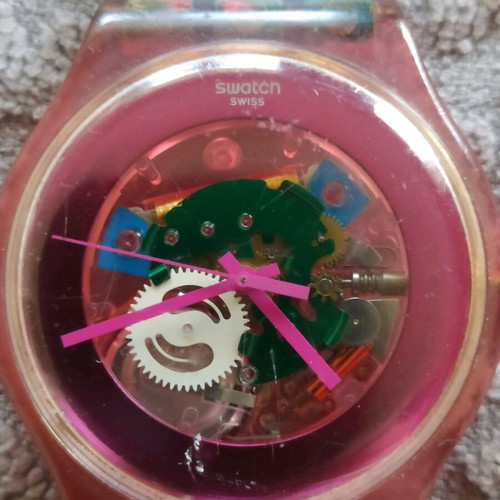 Swatch unicex watch used with transparent case and pink plastic strap