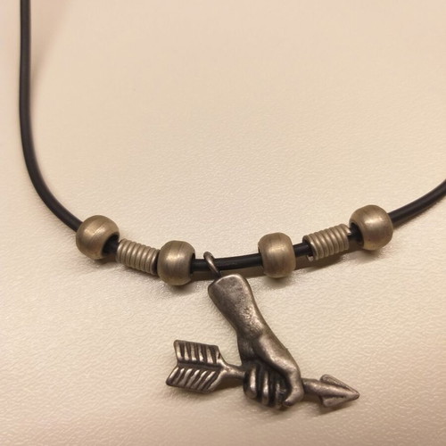 Short necklace used with hand holding arrow pendant in white metal