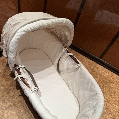 Baby bassinet with woven wicker base and hood