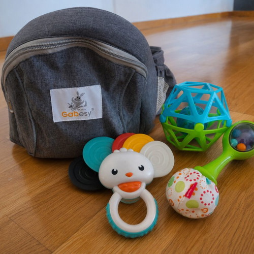 Gabesy ergonomic hip seat carrier used with branded baby toys