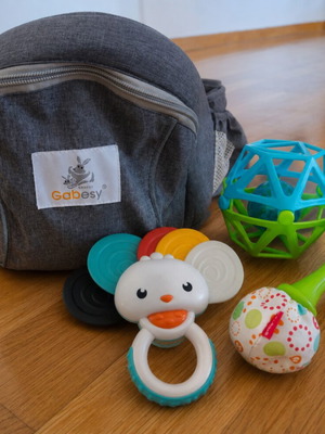 Gabesy ergonomic hip seat carrier used with branded baby toys