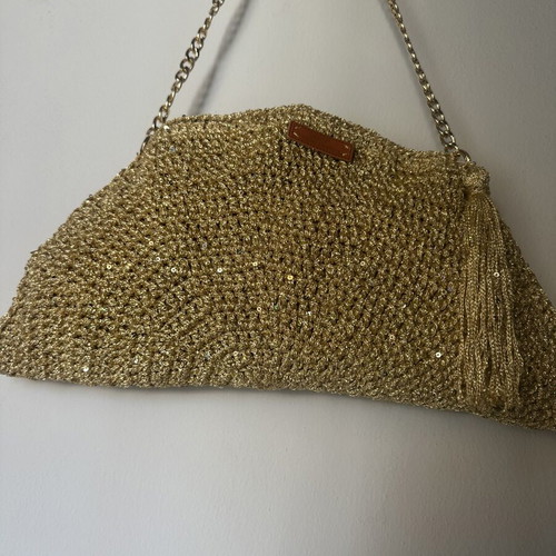 Handmade knitted shoulder bag in gold with decorative tassel