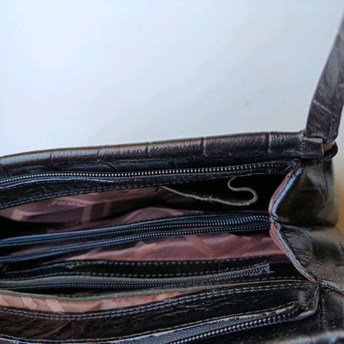 Black shoulder bag used with sturdy construction and multiple pockets