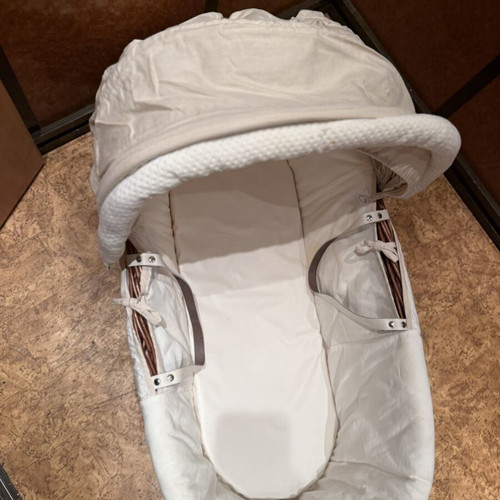 Baby bassinet with woven wicker base and hood