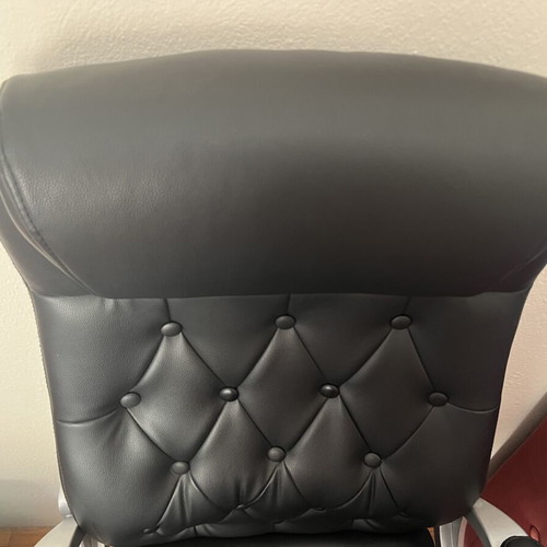 Office chair with black faux leather upholstery and button-tufted back