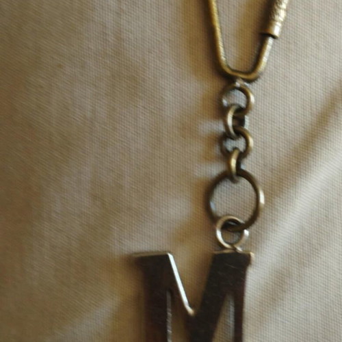 Bronze keychain key holder with monogram M on chain used