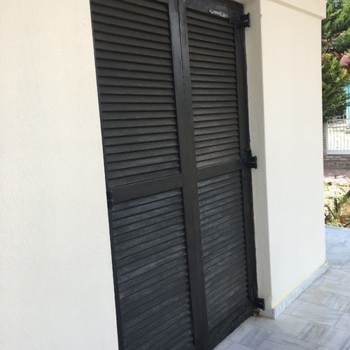 Village-style balcony doors and wooden window used with screen