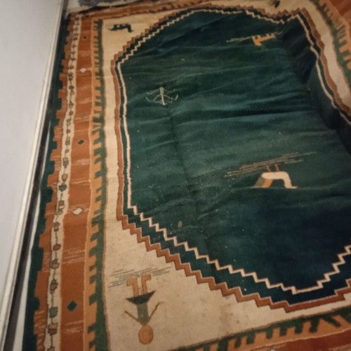 Turquoise machine-made rug used with animal and human designs
