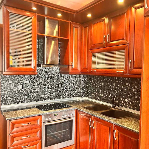 Corner kitchen made of solid cherry wood with extractor hood used