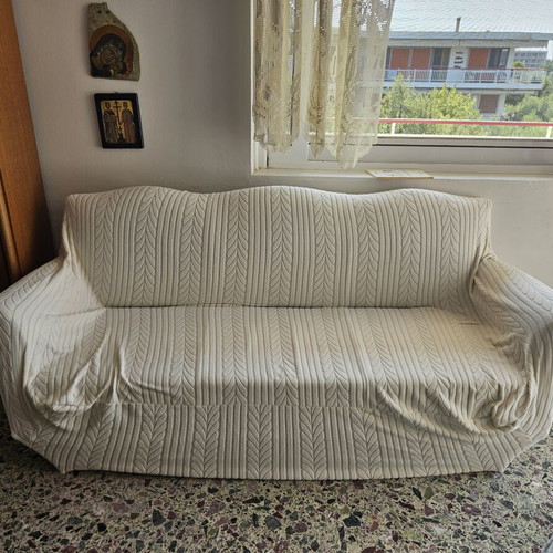 Elastic sofa cover for three-seater couch with fastening cords
