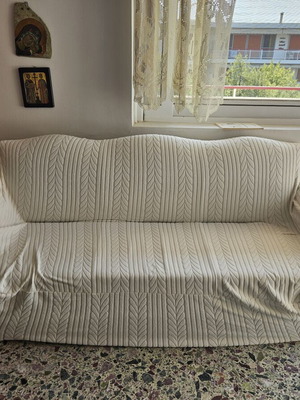 Elastic sofa cover for three-seater couch with fastening cords