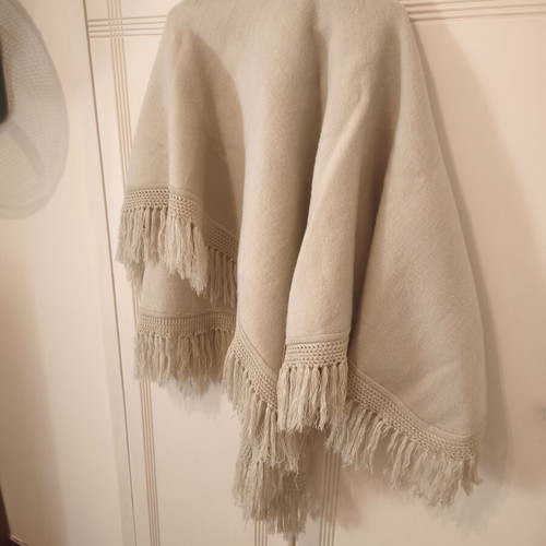 Knitted women's cape 100% wool, beige with fringes