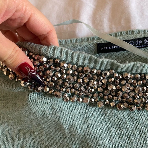 Thin turquoise sweater used with neckline details