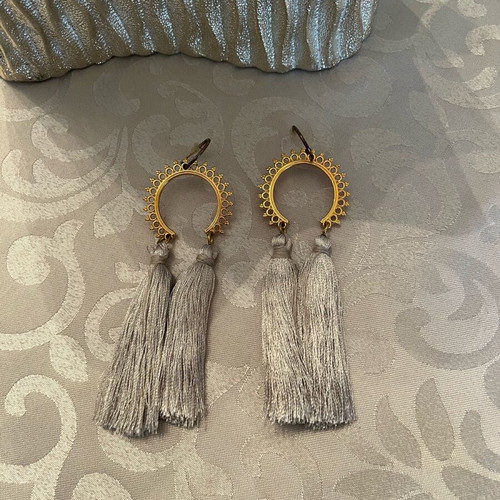 Dangling earrings used with grey tassels and gold details