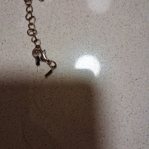 Hamsa pendant with transparent synthetic fishing line used