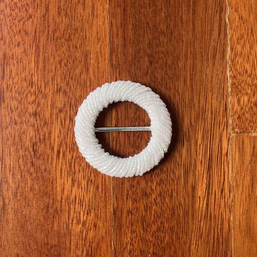 Belt buckle with small white beads