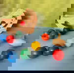  2 Βρεφικά ξύλινα παιχνίδια Plan Toys. Θαυματουργός πάγκος σε σχήμα μισοφέγγαρου με 8 χρωματιστές μπάλες και Βάση γεωμετρικών σωμάτων.