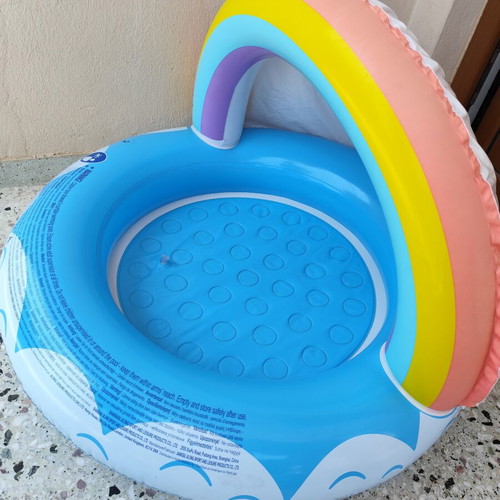 Blue children's pool with canopy used, rainbow design