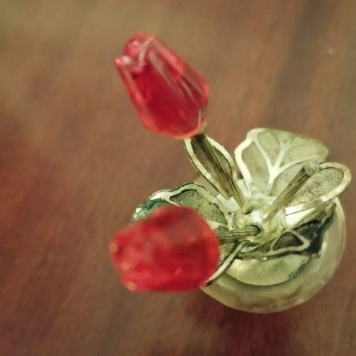 Glass bottle stopper used with decorative flowers and metal leaves