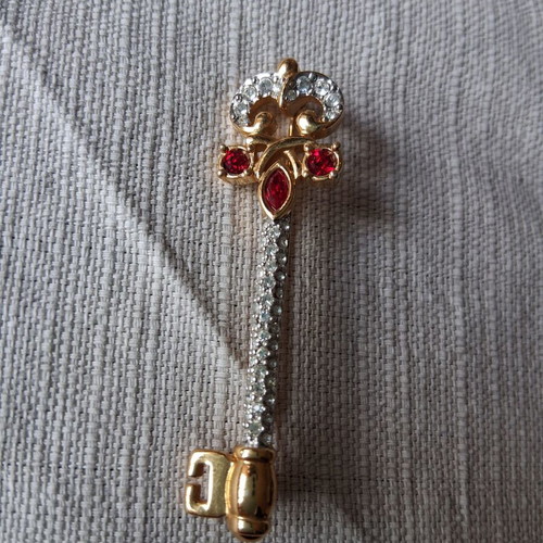 Metal key-shaped pin like new, multicolored, gold tone
