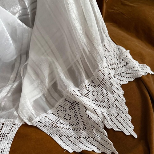 Large white table linen used with lace